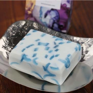 Blue/white oblong bar of soap with translucent fresh blue ribbons through it. Minimum weight 95g.