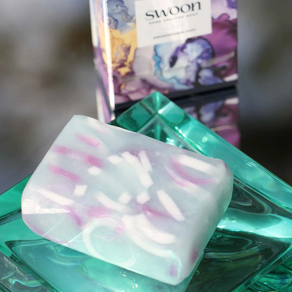 Sparkling misty pale blue/green translucent oblong soap with ribbon accents of white and pink.